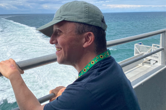 Danny står ved havet og smiler, efter b-near® har givet mere ro og tryg kontakt i hverdagen